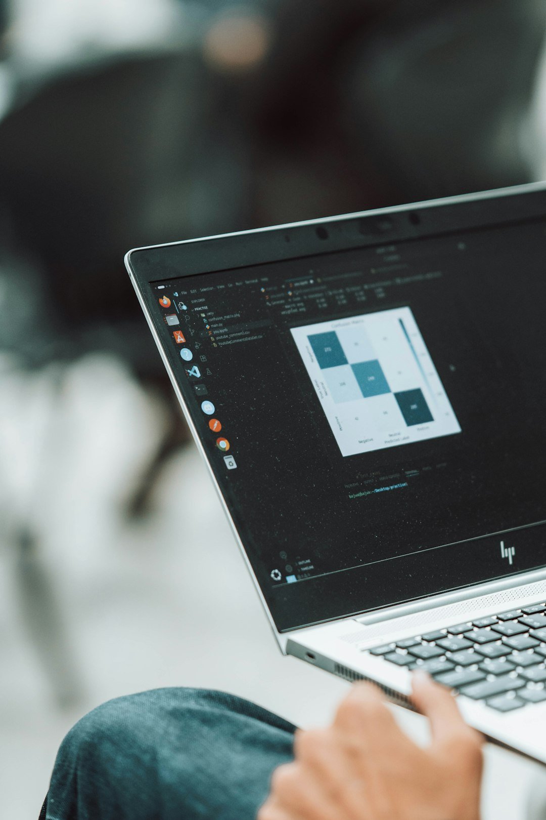 A focused university student working on a laptop in a quiet library space, surrounded by bookshelves. Natural light adds a calm academic vibe.