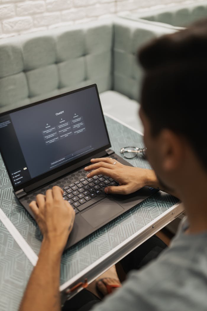 Man using a laptop with a technology interface screen in a modern setting.